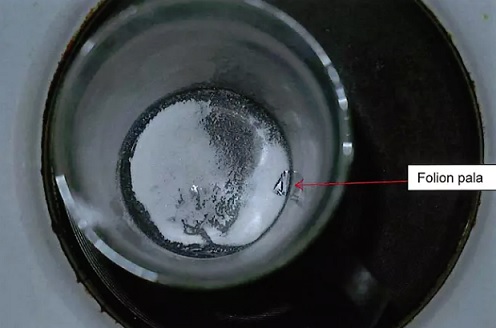 Keittiön lieden päällä oleva muki, jonka pohjalla valkoista jauhetta, sekä lääkkeen läpipainopakkauksen folionpala. Tutkimuksissa selvisi, että mukissa oleva valkoinen jauhe sisältää loratsepaamia. (KUVA: LÄNSI-UUDENMAAN POLIISILAITOS)