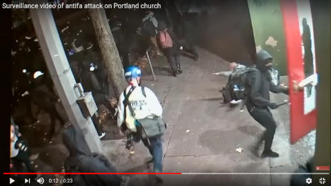Enimmäkseen rauhanomainen rottalauma työssään portlandilaisen kirkon ovella, mukana myös toimittelija.jpg