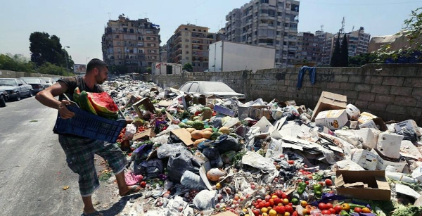 Mies tyhjentää roskiaan kasaan joka on syntynyt Beirutiin jätekriisin seurauksena. Mitään roskien lajittelua Libanonissa ei tietenkään harrasteta.jpg