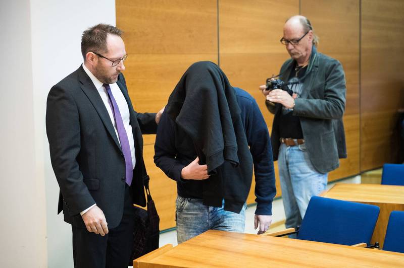 Kahdesta taposta syytetty piiloutuu hupparin alle. Kuva Timo Marttila/Aamulehti