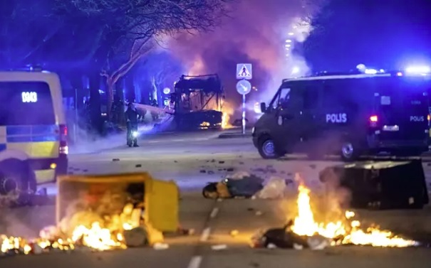 Mellakat jatkuivat pitkin yötä pääsiäisen aikaan. Kuvassa roska-astiat roihuavat ja linja-auto on syttynyt tuleen mellakoitsijoiden toimesta Malmössä. KUVA: JOHAN NILSSON / LEHTIKUVA