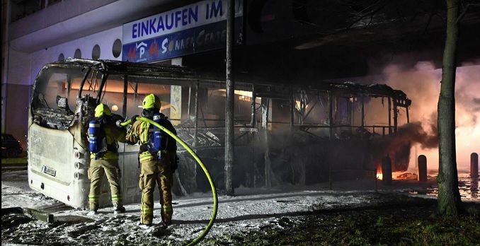 Palomiehet sammuttivat palavaa bussia Berliinissä uudenvuodenaattona. KUVA: PAUL ZINKEN / DPA.