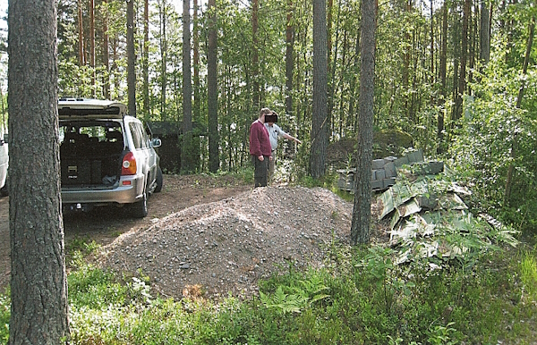 Jesse osoittaa ruumiin ensimmäistä kätköpaikkaa lautakasan vieressä.jpg