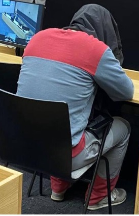 Kauppakeskuspuukotuksesta syytetty oli vetänyt takin päänsä päälle median kuvatessa häntä oikeudenkäynnin aluksi. Kuva: Marjo Valtavaara / HS