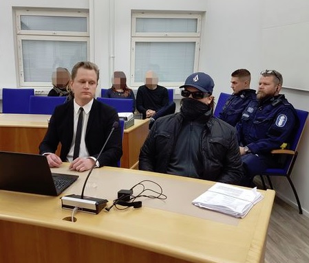 Murhasta syytetty mies pukeutui oikeudenkäynnin alussa kasvot peittävään huiviin ja aurinkolaseihin. KARI KAUPPINEN