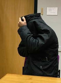 Vangitsemisoikeudenkäyntiin tuotu mies piiloutui takkinsa suojiin. MINNA JALOVAARA